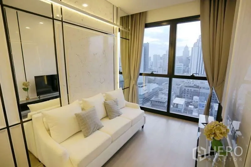 Condominium for rent in Watthana, Bangkok - Bright living room with white sofa, marble accents and floor-to-ceiling windows over the Asoke skyline.
