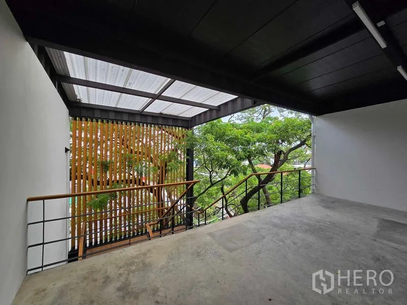 Home Office for rent in Chatuchak, Bangkok - Sheltered terrace with metal roof and wood louver screen facing green treetops.