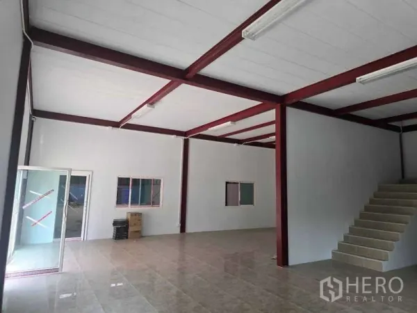 Warehouse for rent in Mueang Samut Sakhon, Samut Sakhon - Ground-floor warehouse office area with tiled floor, red steel columns, and fluorescent lighting.