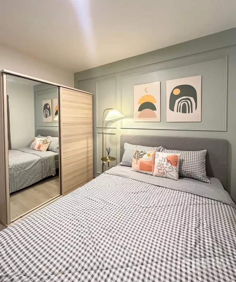 Townhouse for rent in Prawet, Bangkok - Guest bedroom with checkered bedding, mirrored sliding wardrobe and framed art.