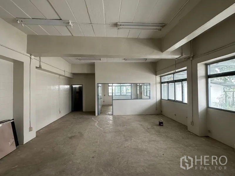 Factory for rent in Lam Luk Ka, Pathum Thani - Upper-floor office workspace with large windows and fluorescent lighting.