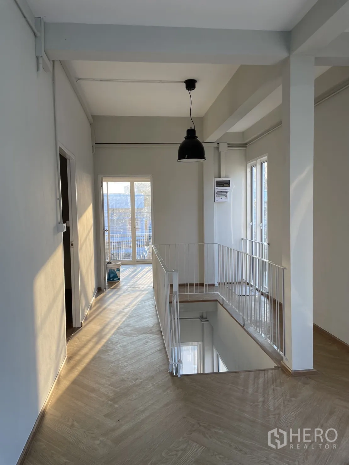 Detached House for rent or sale in Din Daeng, Bangkok - Upper landing with industrial pendant, wood floors and railing around stairwell.