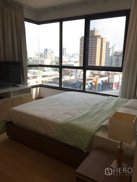 Condominium for rent in Watthana, Bangkok - Corner bedroom with large windows offering panoramic Bangkok city views.