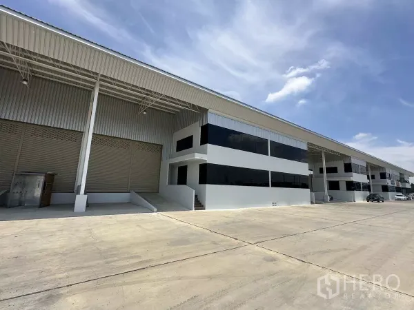 Warehouse for rent in Wang Noi, Phra Nakhon Si Ayutthaya - Row of warehouses with dark glass office fronts and wide truck access under covered canopies.