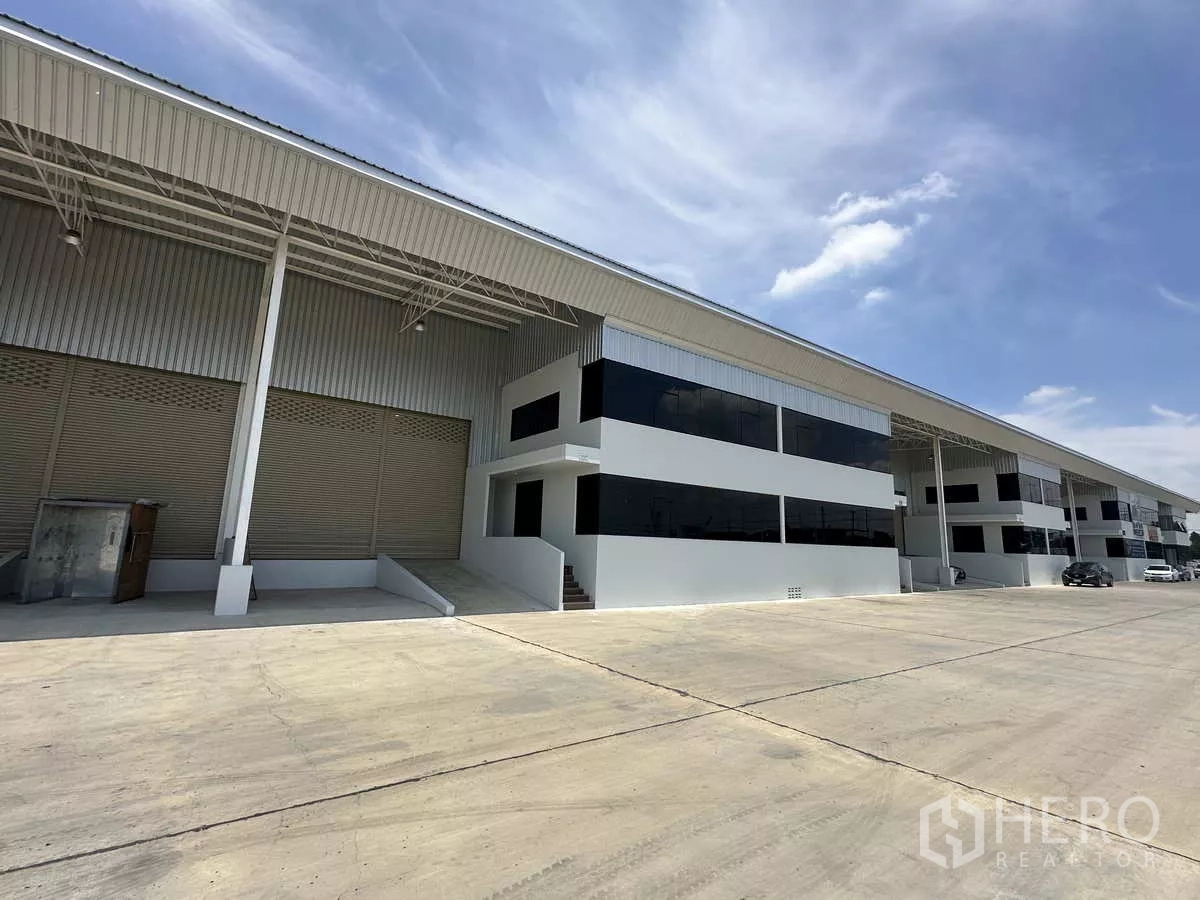Warehouse for rent in Wang Noi, Phra Nakhon Si Ayutthaya - Row of warehouses with dark glass office fronts and wide truck access under covered canopies.