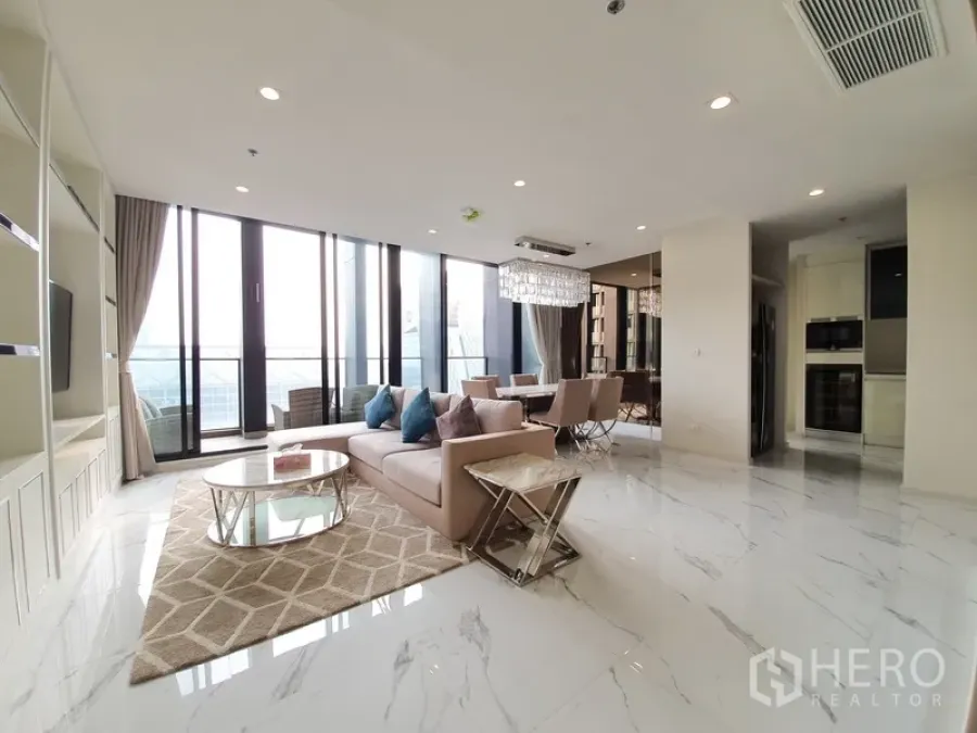 Condominium for rent in Pathum Wan, Bangkok - Bright open-plan living and dining area with marble floors, floor-to-ceiling windows and a balcony with city views.