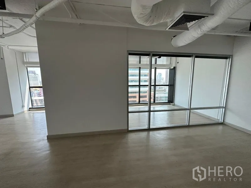 Office Space for rent - Open area with ducted ceiling beside a glass‑walled office section and city views.