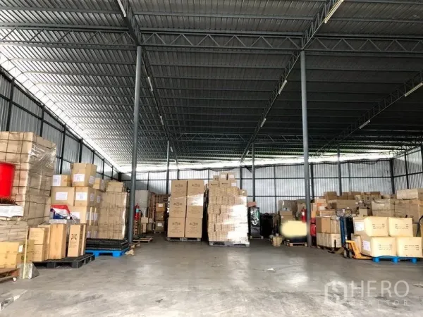 Warehouse for rent in Pak Kret, Nonthaburi - Wide interior view showing clear floor space, steel trusses and a central loading area.