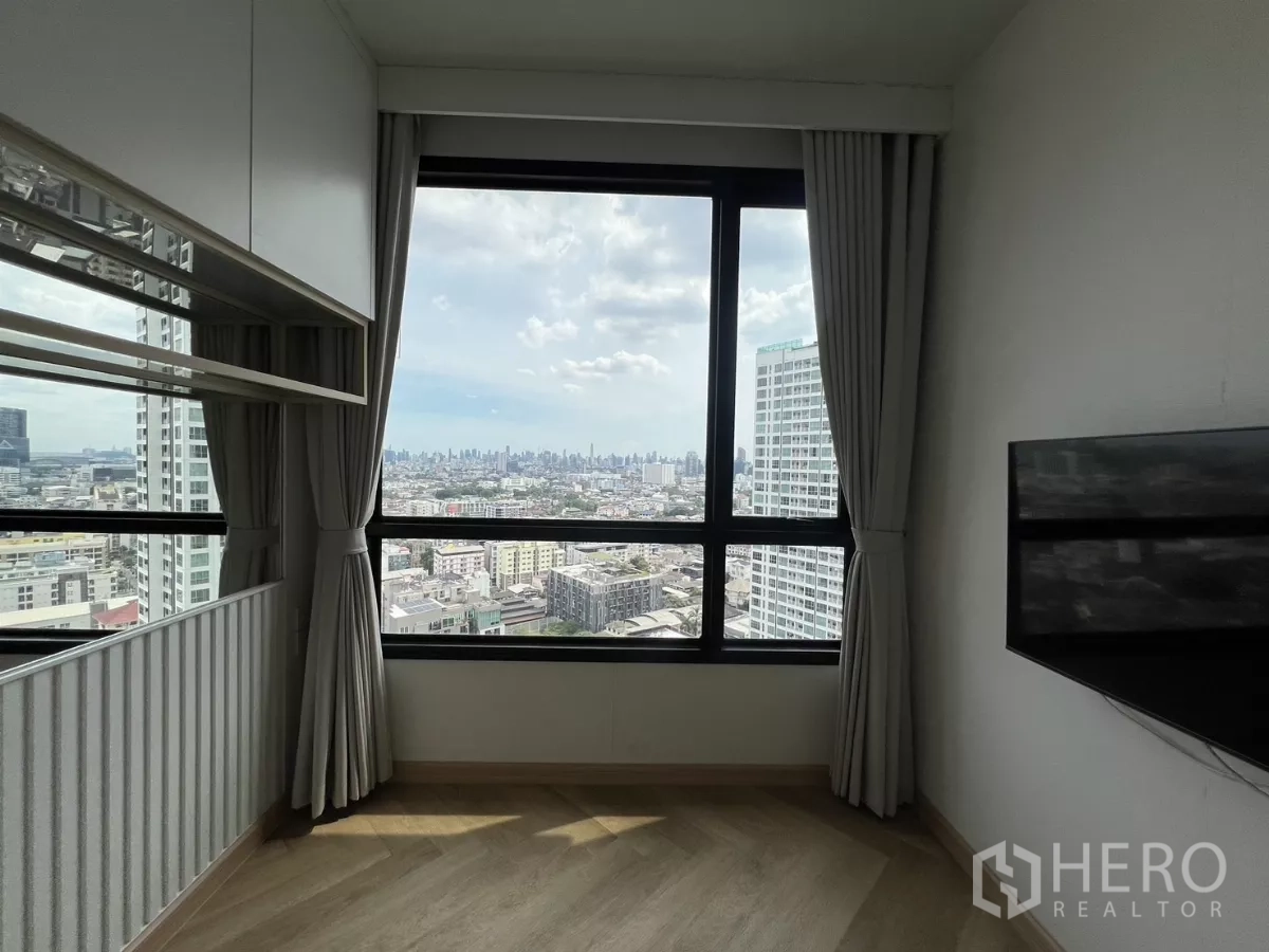 Condominium for rent or sale in Chatuchak, Bangkok - Corner window close‑up in the second bedroom framing the Bangkok skyline.