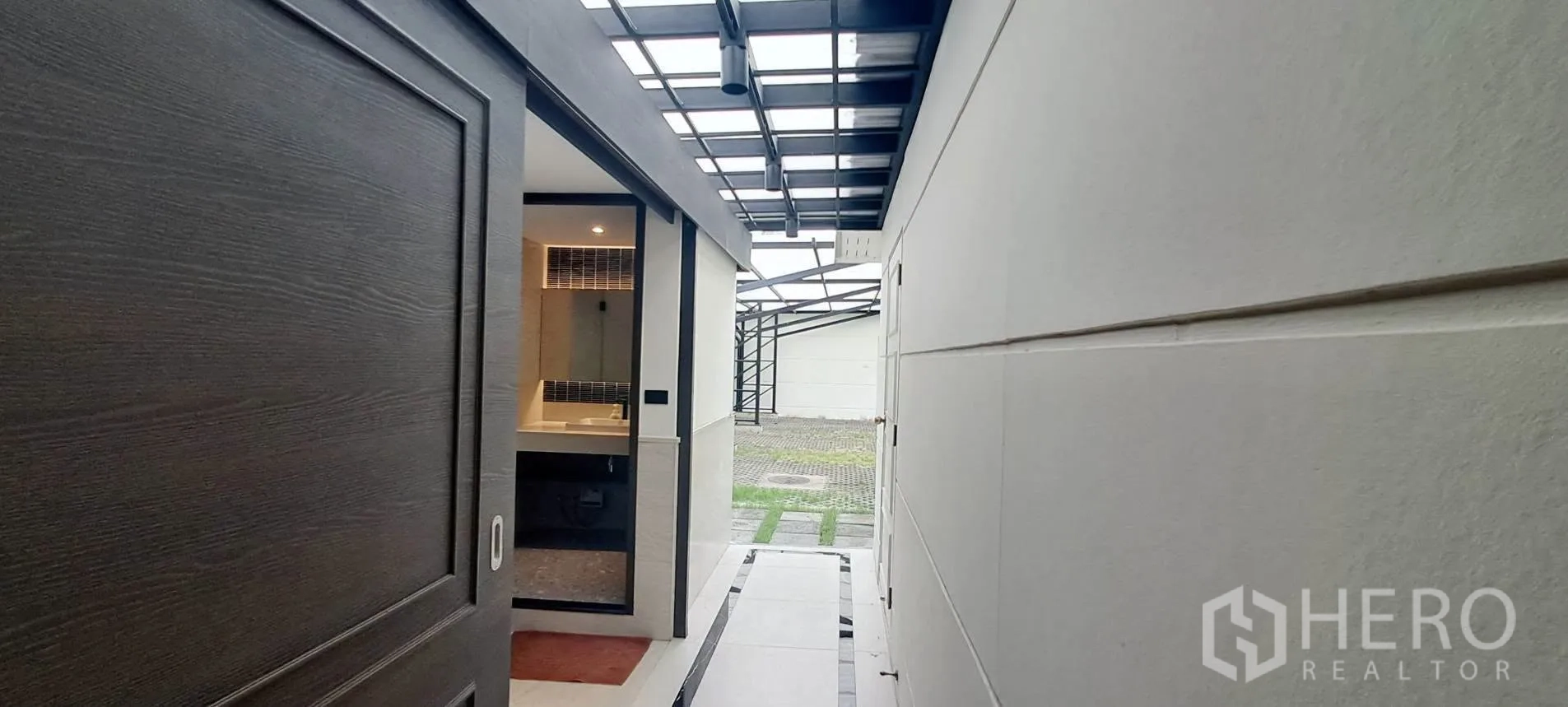 Home Office for rent in Lat Phrao, Bangkok - Covered walkway beside the building leading to a bathroom entrance and courtyard.