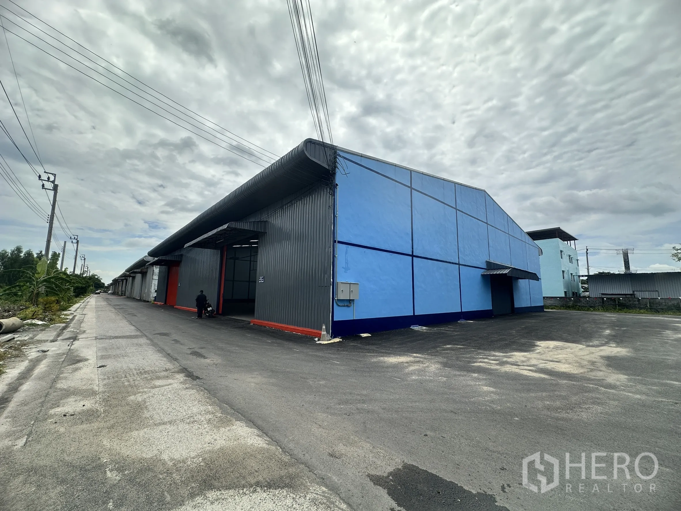 Warehouse for rent in Lat Krabang, Bangkok - Corner view of the warehouse block with a paved forecourt and service road.