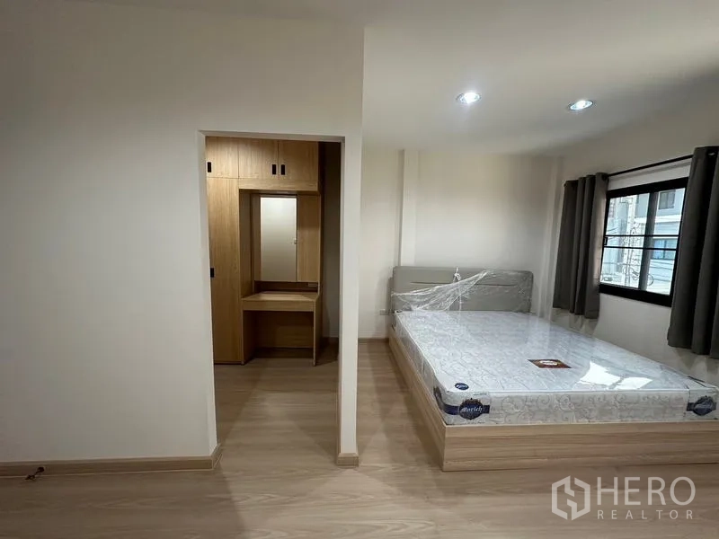 Townhouse for rent or sale in Phra Khanong, Bangkok - Walk-in closet with full-height built-in cabinetry and vanity.