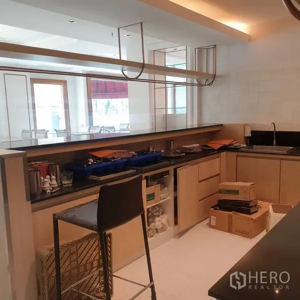 Retail Space for rent in Khlong Toei, Bangkok - Service counter and prep area with open shelving, sink, and a glass partition facing the dining space.