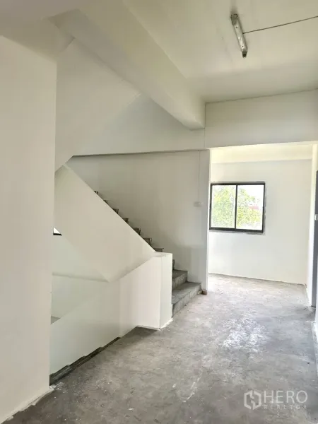 Warehouse for rent in Bang Phli, Samut Prakan - Stairwell and corridor with natural light from a window inside the building.