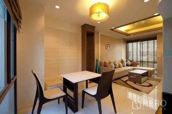 Townhouse for rent in Phra Khanong, Bangkok - Dining nook with two chairs, pendant light and view to the open-plan living area.