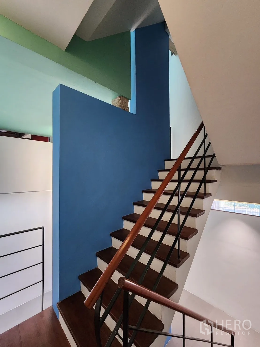 Home Office for rent in Chatuchak, Bangkok - Internal staircase with wooden treads, metal balustrade, and blue accent wall.