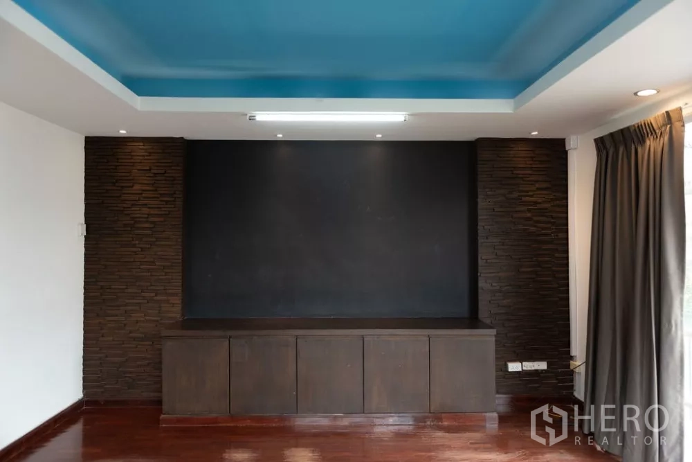 Home Office for rent in Lat Phrao, Bangkok - Feature wall and cabinet with blue tray ceiling and recessed lighting.