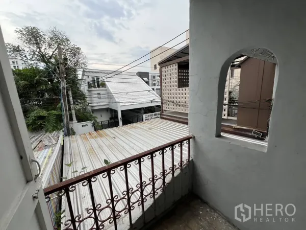 Townhouse for rent in Watthana, Bangkok - Small balcony with metal railing overlooking low-rise neighborhood.