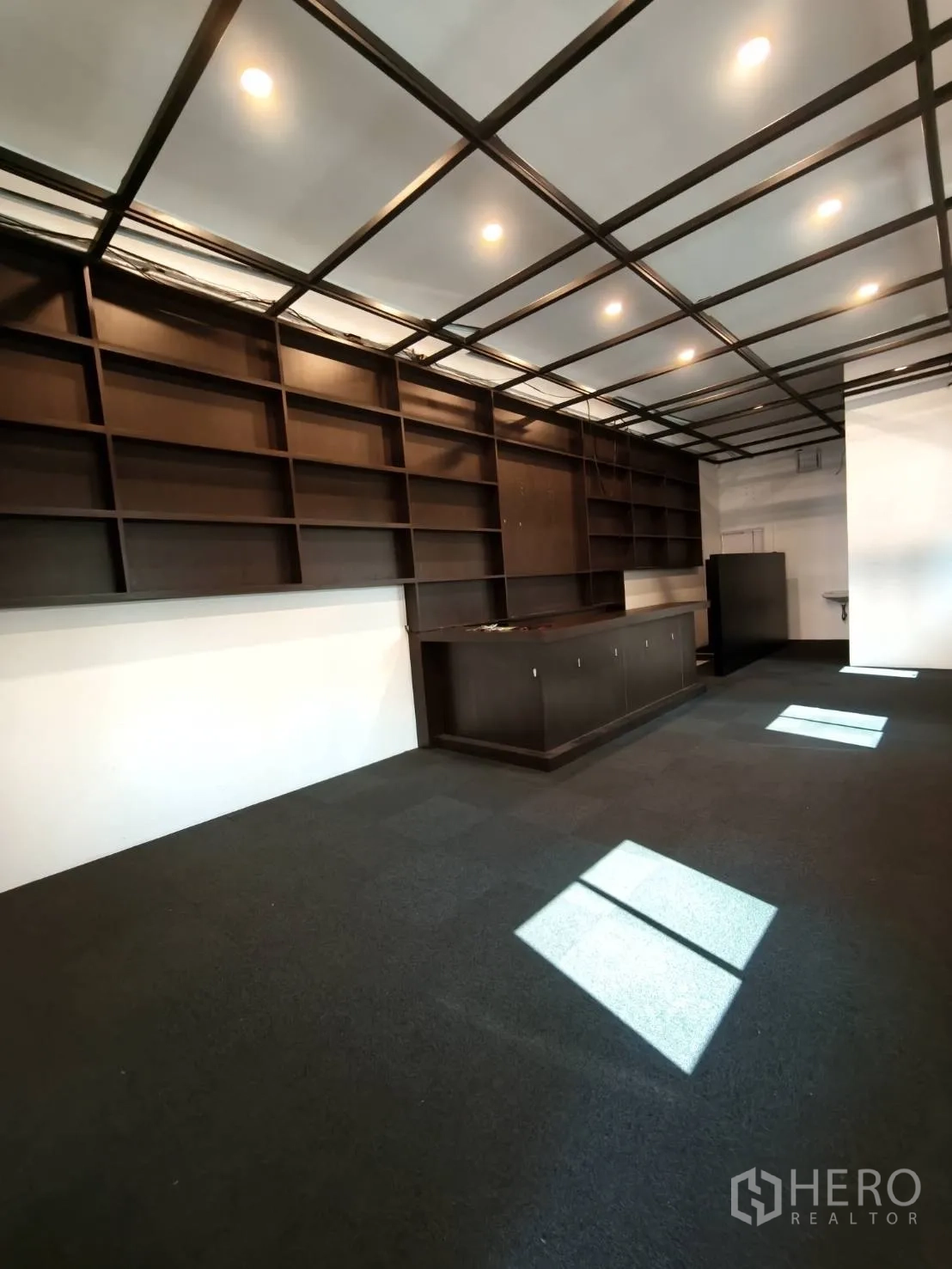 Retail Space for rent in Watthana, Bangkok - Open-plan retail room with grid ceiling lights, shelving, and a service counter.