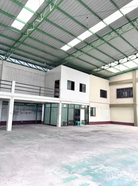 Warehouse for rent or sale in Thanyaburi, Pathum Thani - Spacious covered loading area with green steel truss roof, mezzanine and glass-fronted office.