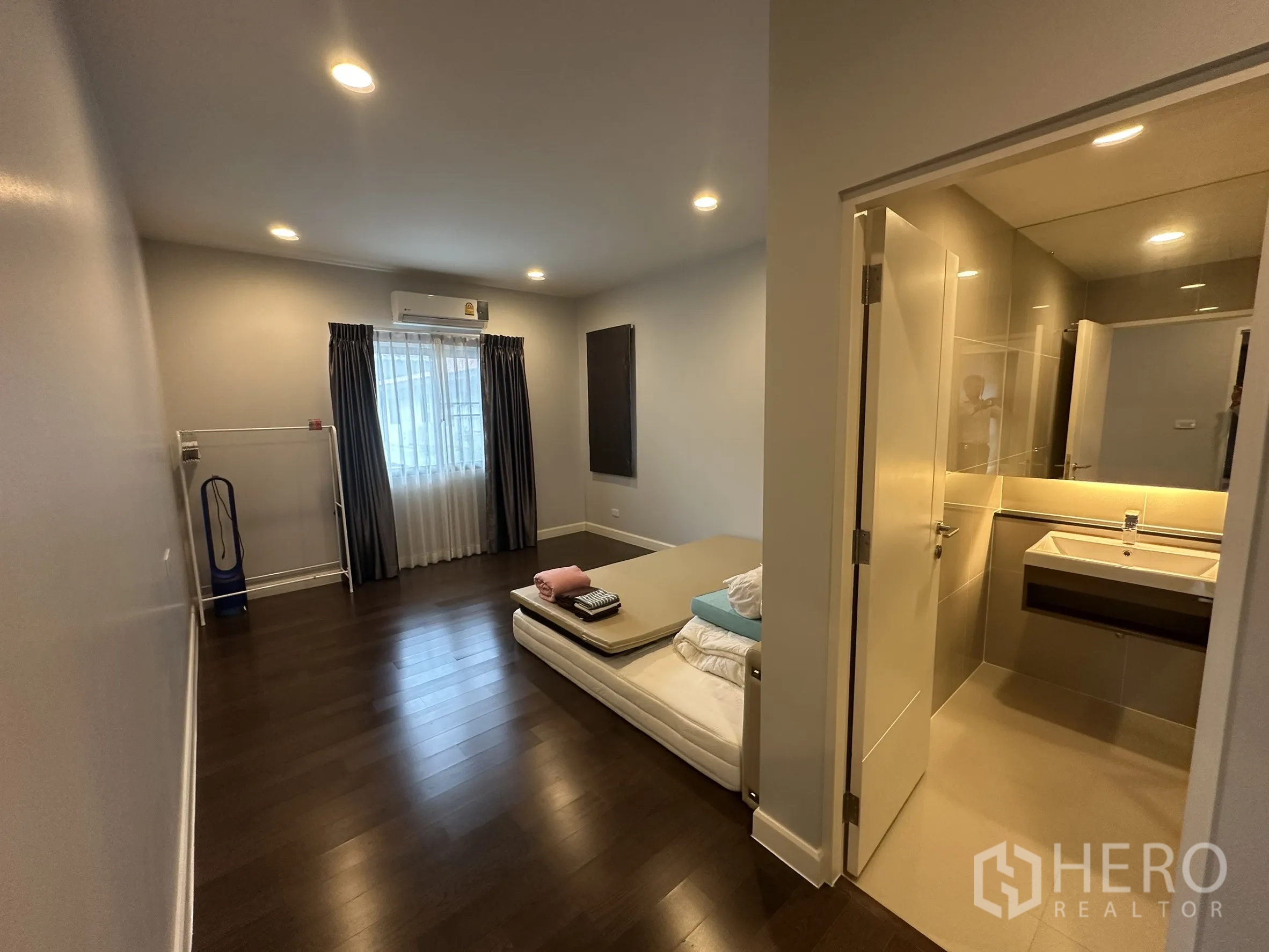 Detached House for rent in Lam Luk Ka, Pathum Thani - Secondary bedroom with ensuite entry and dark wood floor.