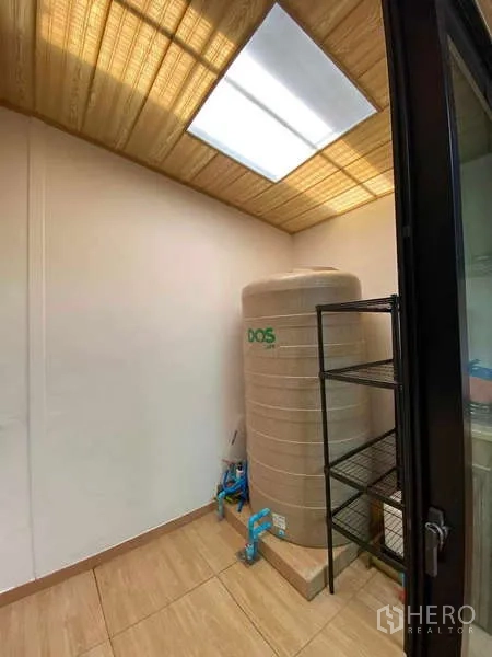 Townhouse for rent or sale in Bang Kapi, Bangkok - Utility room featuring a large water tank, metal shelving and skylight ceiling.