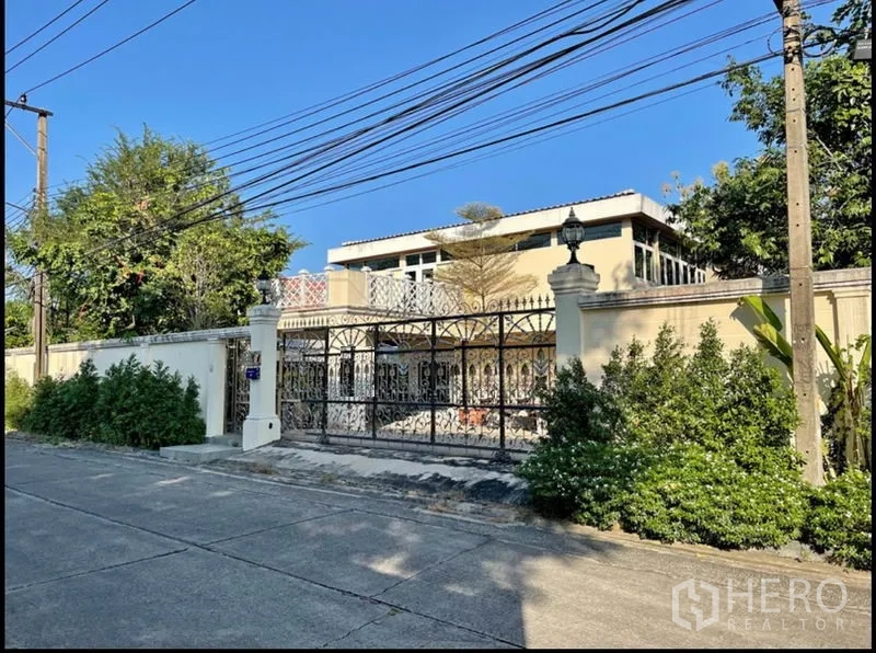 Detached House for rent in Khlong Toei, Bangkok - Street view of gated property with ornate metal gate and tall perimeter wall.