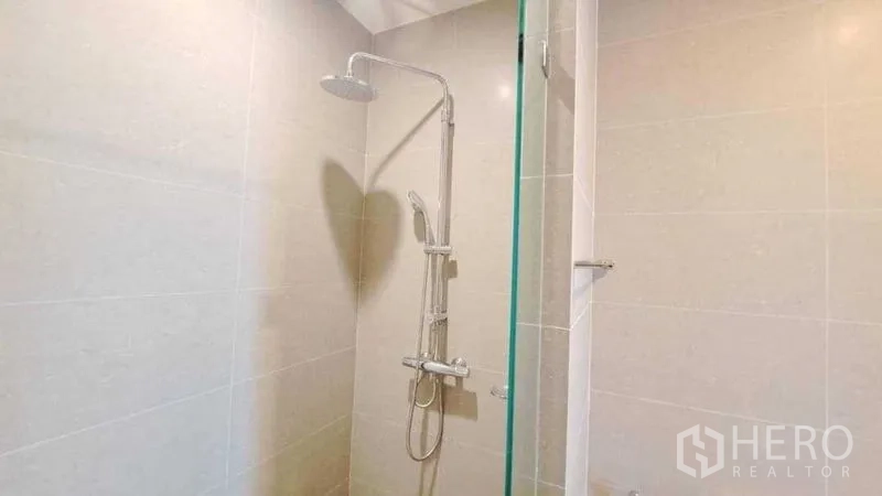 Condominium for rent or sale in Pathum Wan, Bangkok - Close-up of rainfall shower and handheld set in a tiled bathroom.