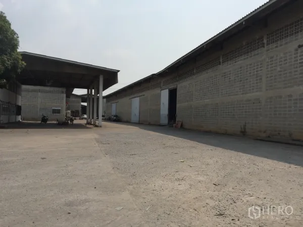 Warehouse for rent in Mueang Pathum Thani, Pathum Thani - Driveway between warehouse blocks with canopy roof, multiple loading doors and ample truck turning space.
