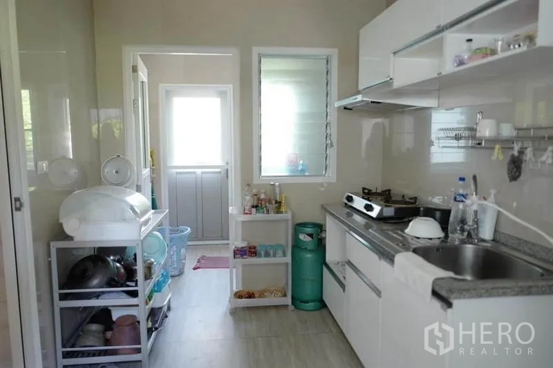 บ้าน ขายในPak Kret, Nonthaburi - โถงครัวเชื่อมสู่ประตูบริการ พร้อมชั้นวางของและหน้าต่าง
