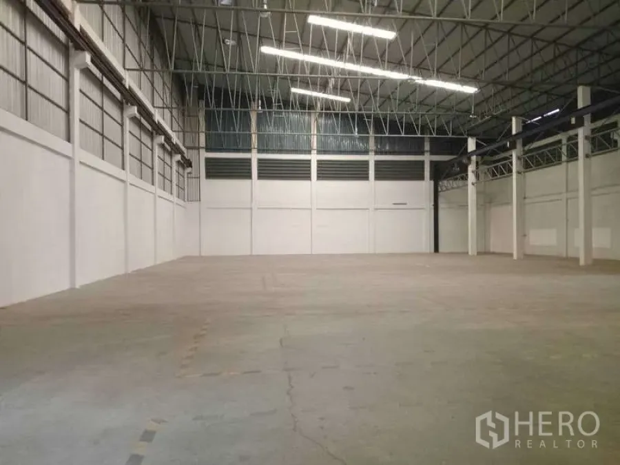 Factory for rent in Mueang Samut Prakan, Samut Prakan - Large open manufacturing space with concrete floor, bright strip lighting and column grid.