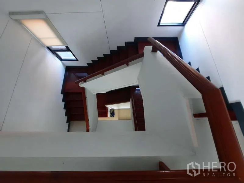 Home Office for rent in Huai Khwang, Bangkok - Top-down perspective of stairwell showing wooden treads and handrail.