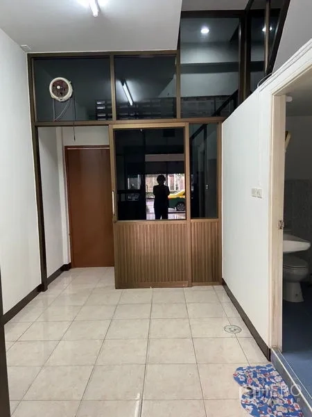 Shophouse for rent in Khlong Toei, Bangkok - Interior view showing glass doors, a private room, and entrance to a restroom.