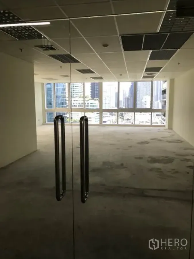 Office Space for rent in Khlong Toei, Bangkok - View through glass entry doors into a bright office with city skyline.