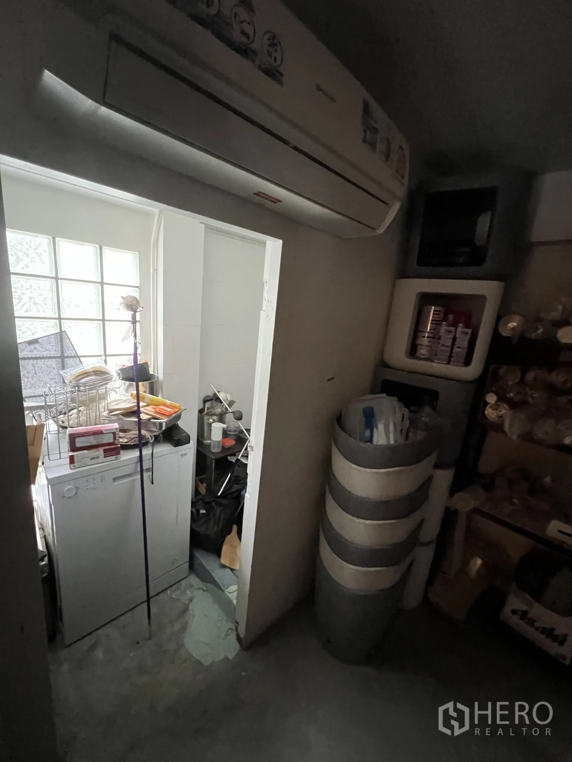 Retail Space for rent in Watthana, Bangkok - Back-of-house utility space with air conditioner, dishwasher, shelving and supplies.