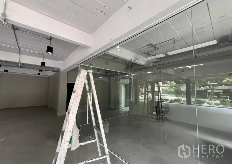 Retail Space for rent in Suan Luang, Bangkok - Retail unit during light fit-out with a ladder beside a full-height glass wall.