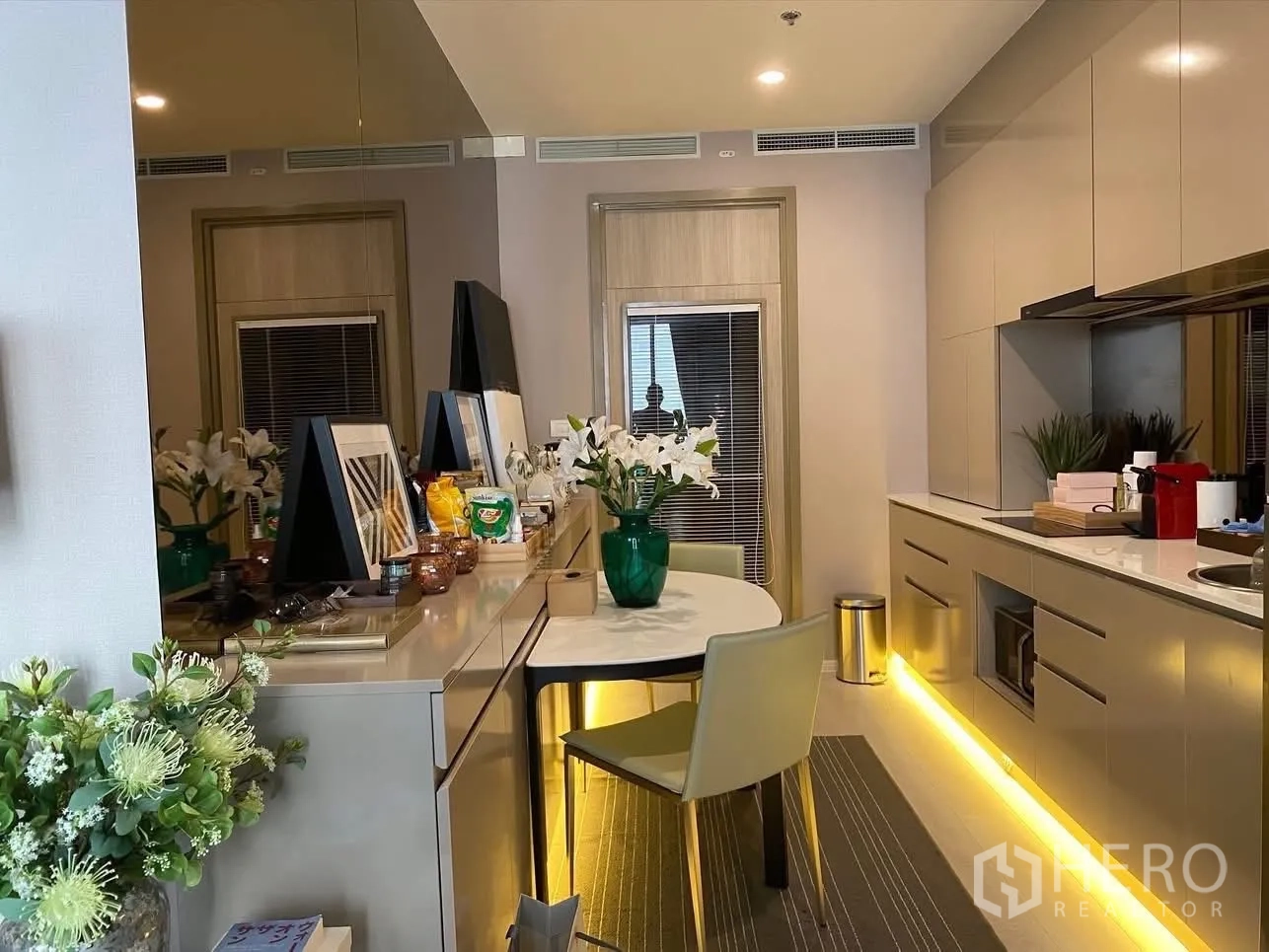 Condominium for rent in Pathum Wan, Bangkok - Contemporary kitchen and dining area with built-in cabinets and under-cabinet LED lighting.