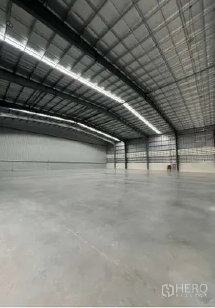 Warehouse for rent in Mueang Rayong, Rayong - Wide, column‑free warehouse space with metal wall panels and bright LED lighting.