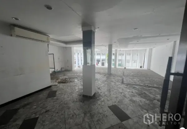 店屋 出租在Khlong Toei, Bangkok - 开放式楼层，白色天花与立柱，临街大窗，地面未完工。