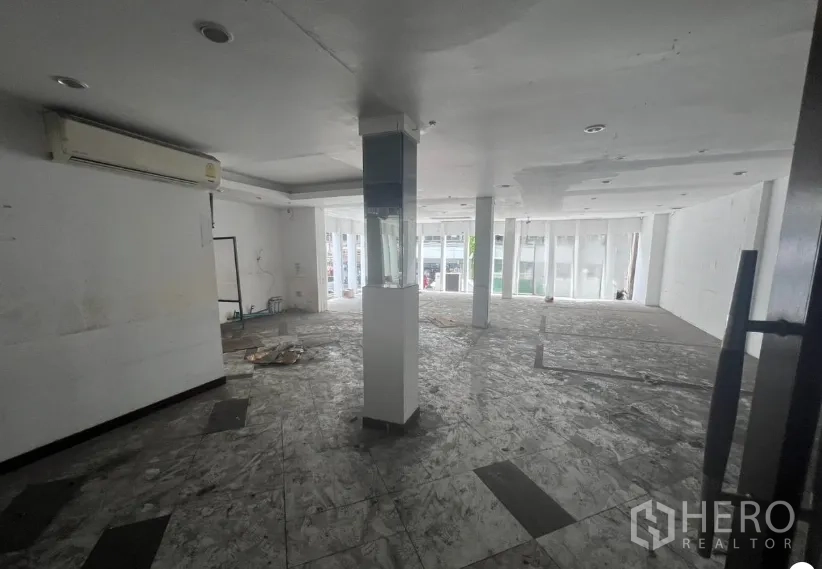 店屋 出租在Khlong Toei, Bangkok - 开放式楼层，白色天花与立柱，临街大窗，地面未完工。