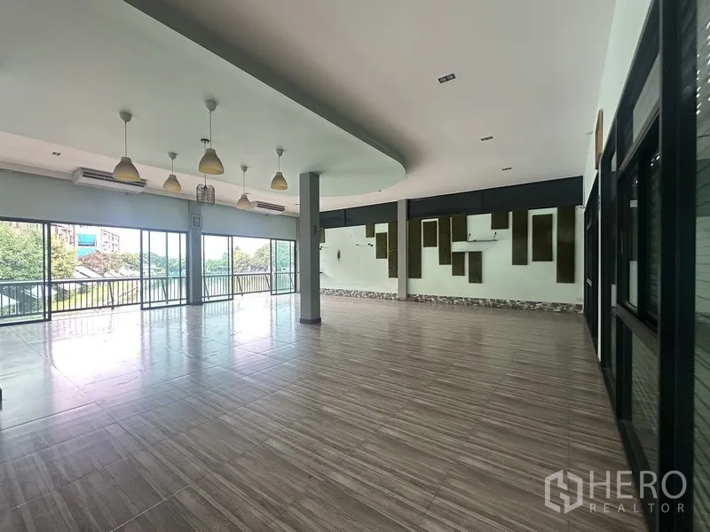 Standalone for rent in Prawet, Bangkok - Lakeside hall with pendant lights, feature wall and sliding glass to the balcony.