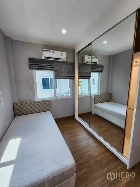 Detached House for rent in Bang Khen, Bangkok - Bright small bedroom with a single bed, mirrored wardrobe, wood floor and air-conditioning.