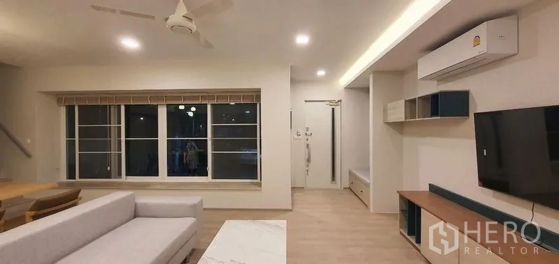 Detached House for rent - Open-plan living area with large windows and TV console.