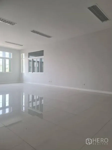 Factory for rent or sale in Lam Luk Ka, Pathum Thani - Large bright office space with reflective tile floors and multiple windows.