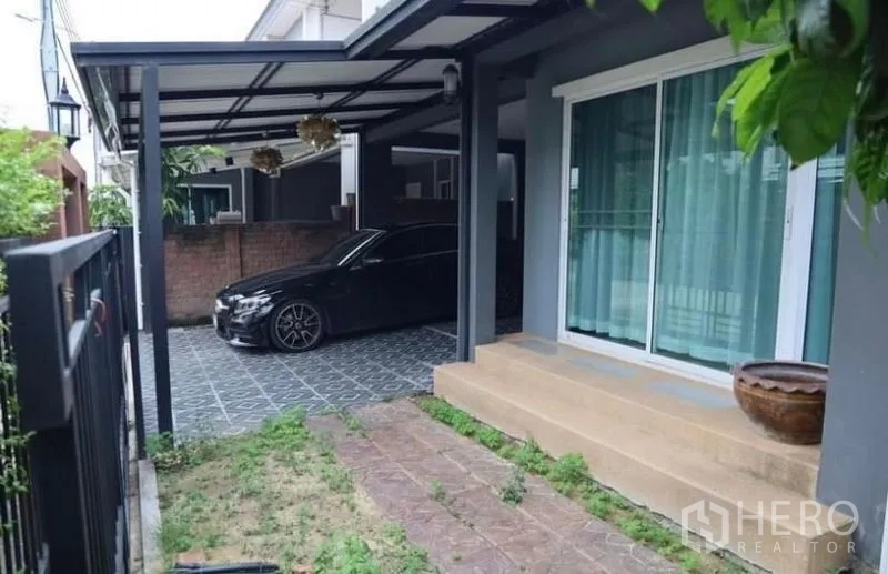 Detached House for rent in Suan Luang, Bangkok - Covered two-car carport with small lawn and sliding glass door entry.