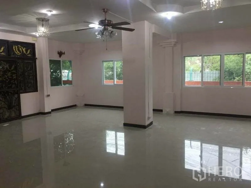 Detached House for rent in Chatuchak, Bangkok - Bright open-plan lounge with multiple windows, ceiling fans and chandeliers.