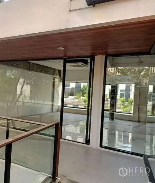 Retail Space for rent - Corner retail unit with floor-to-ceiling glass windows and a wood soffit along an elevated walkway.