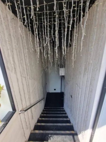 Retail Space for rent in Bang Rak, Bangkok - Stairwell decorated with hanging string lights leading to lower level.