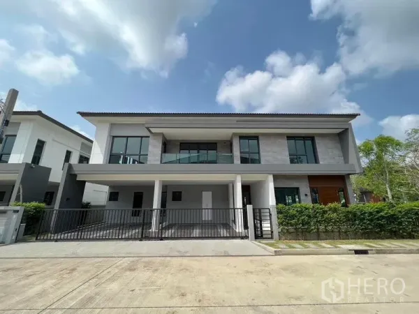 Detached House for rent - Modern two-storey detached house facade with gated double parking and balcony under blue sky.