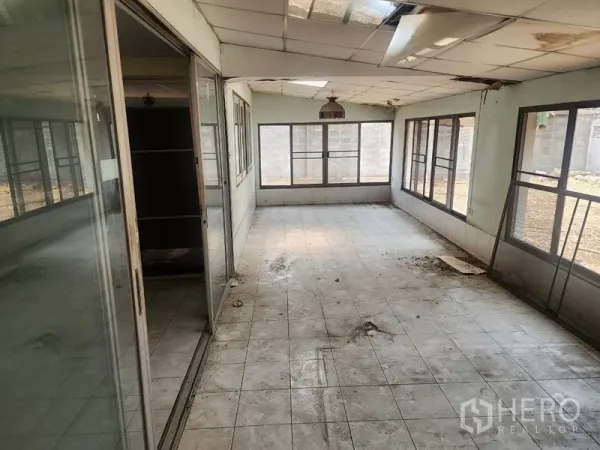Detached House for rent in Watthana, Bangkok - Enclosed sunroom with tiled floor and sliding glass doors, showing renovation needs.